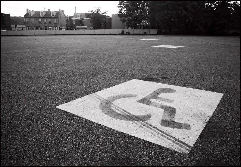 An accessible parking spot in an empty parking lot, in black and white.