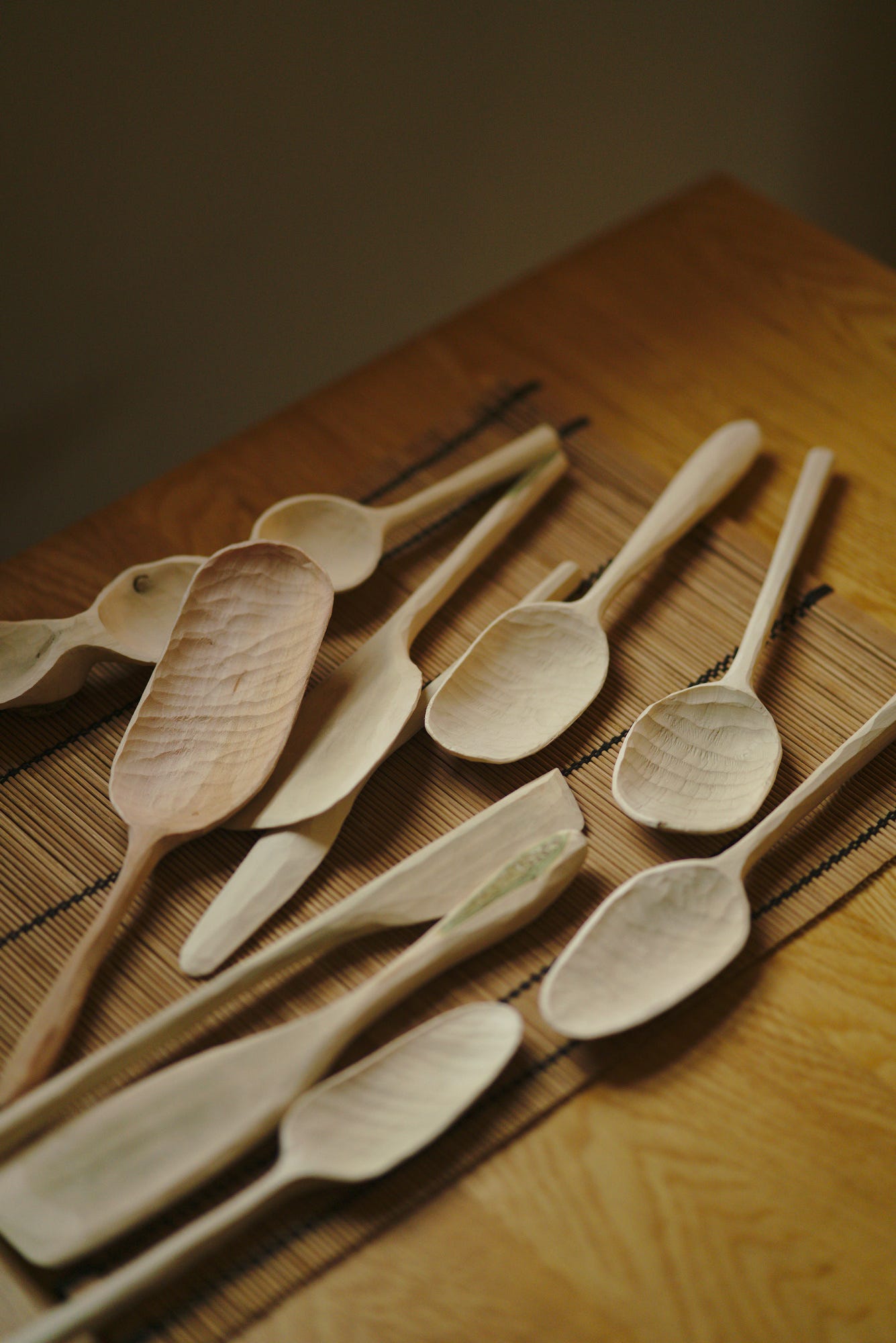 A pile of recently carved large cooking spoons and spatulas, waiting for branding, sanding, and finishing.