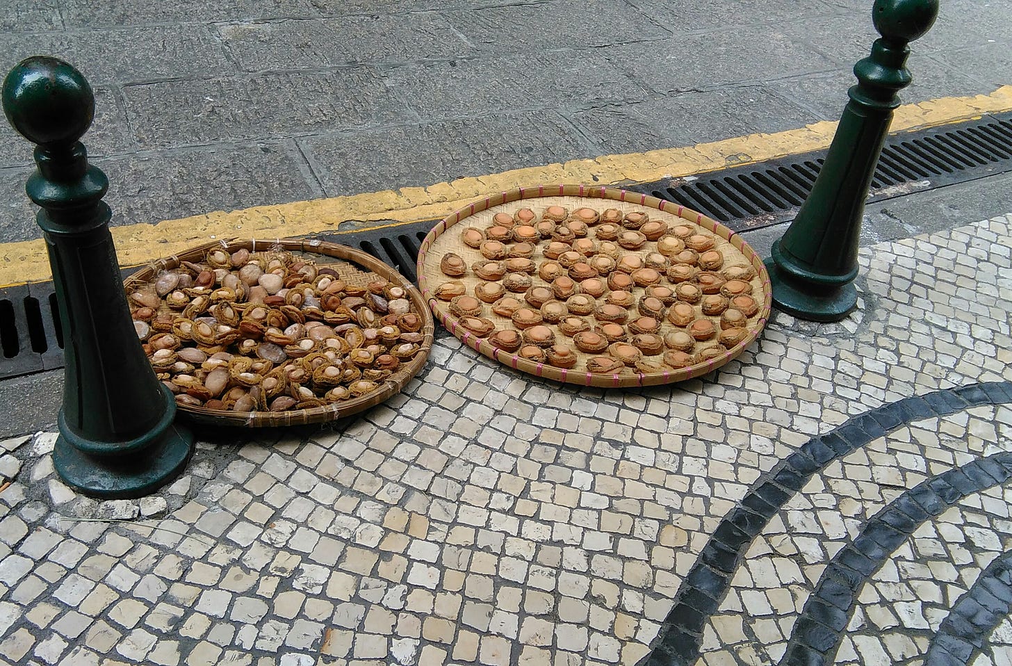 A shot of a pavement in Macau where abalone are drying on large round wicker baskets