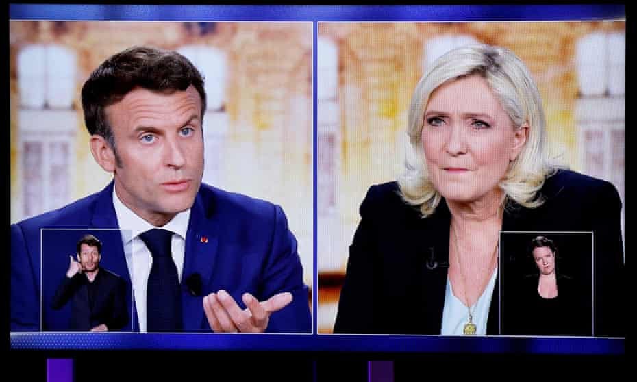 A TV screen displays the debate between Emmanuel Macron and Marine Le Pen.