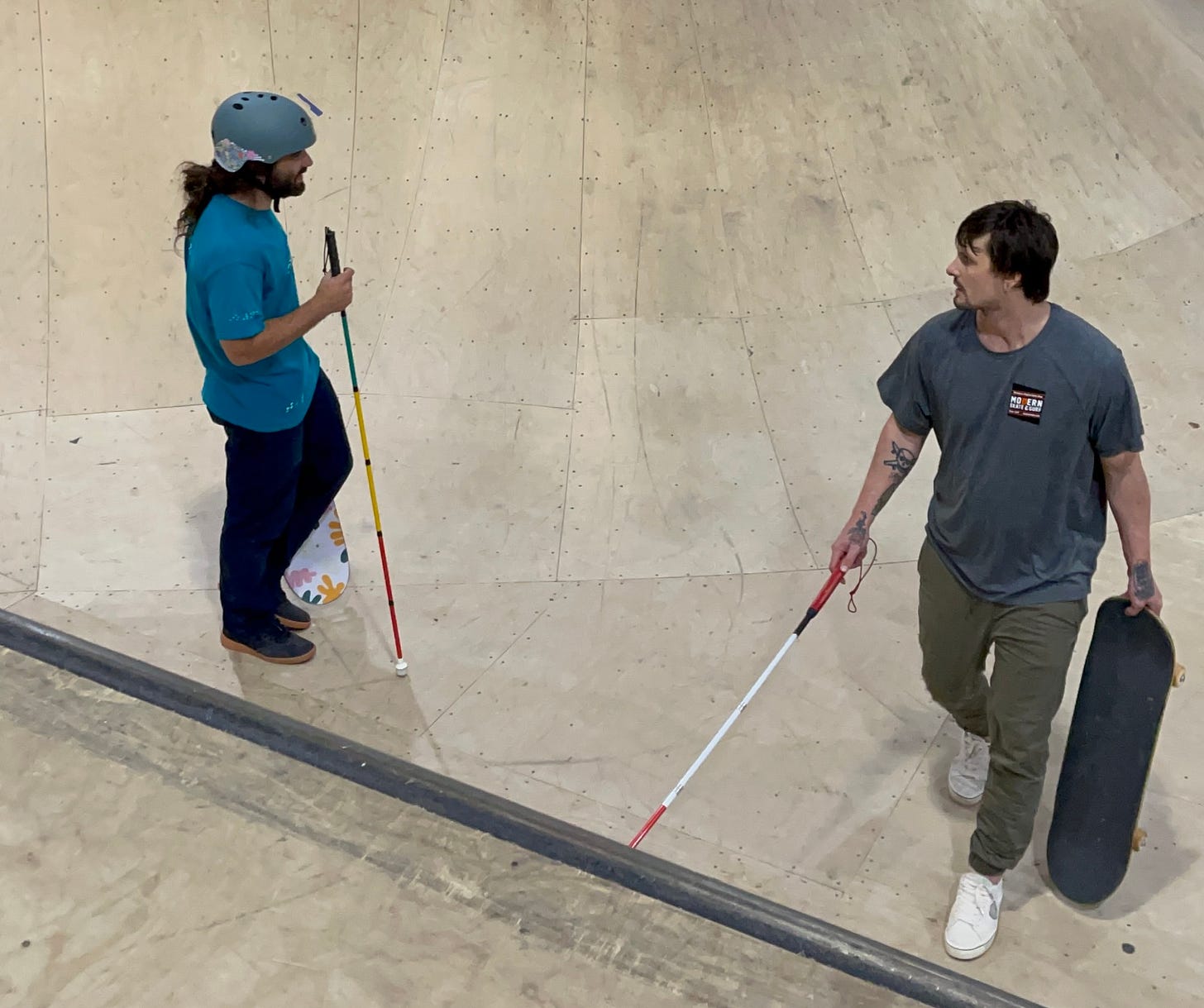 Blind Skater, Anthony Ferraro (left) learns how to navigate the bowl from Blind Skater, Nick Mullins at Modern Skate