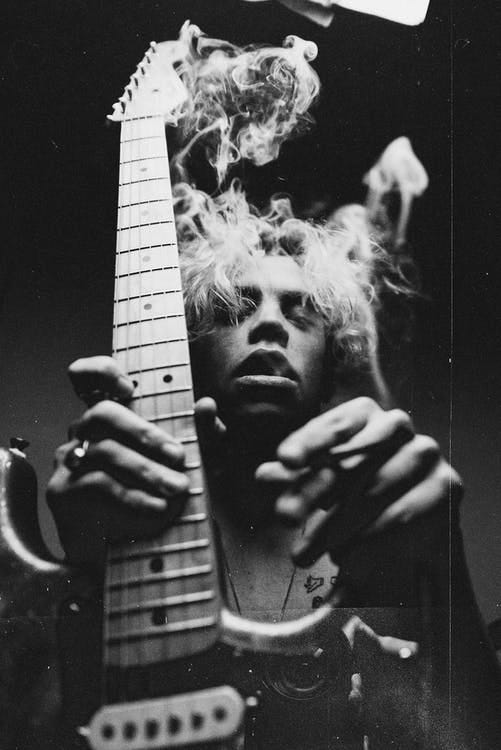 Black and White Photography of a Man Holding Guitar