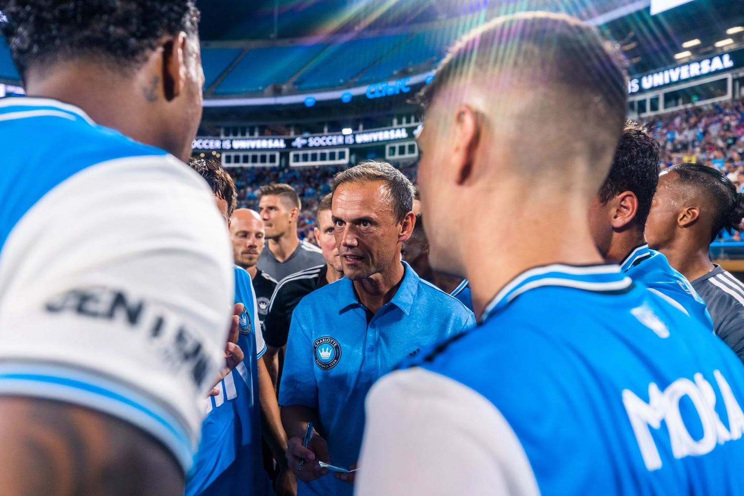 Picture of Charlotte FC Head Coach Christian Lattanzio surrounded by players in a huddle