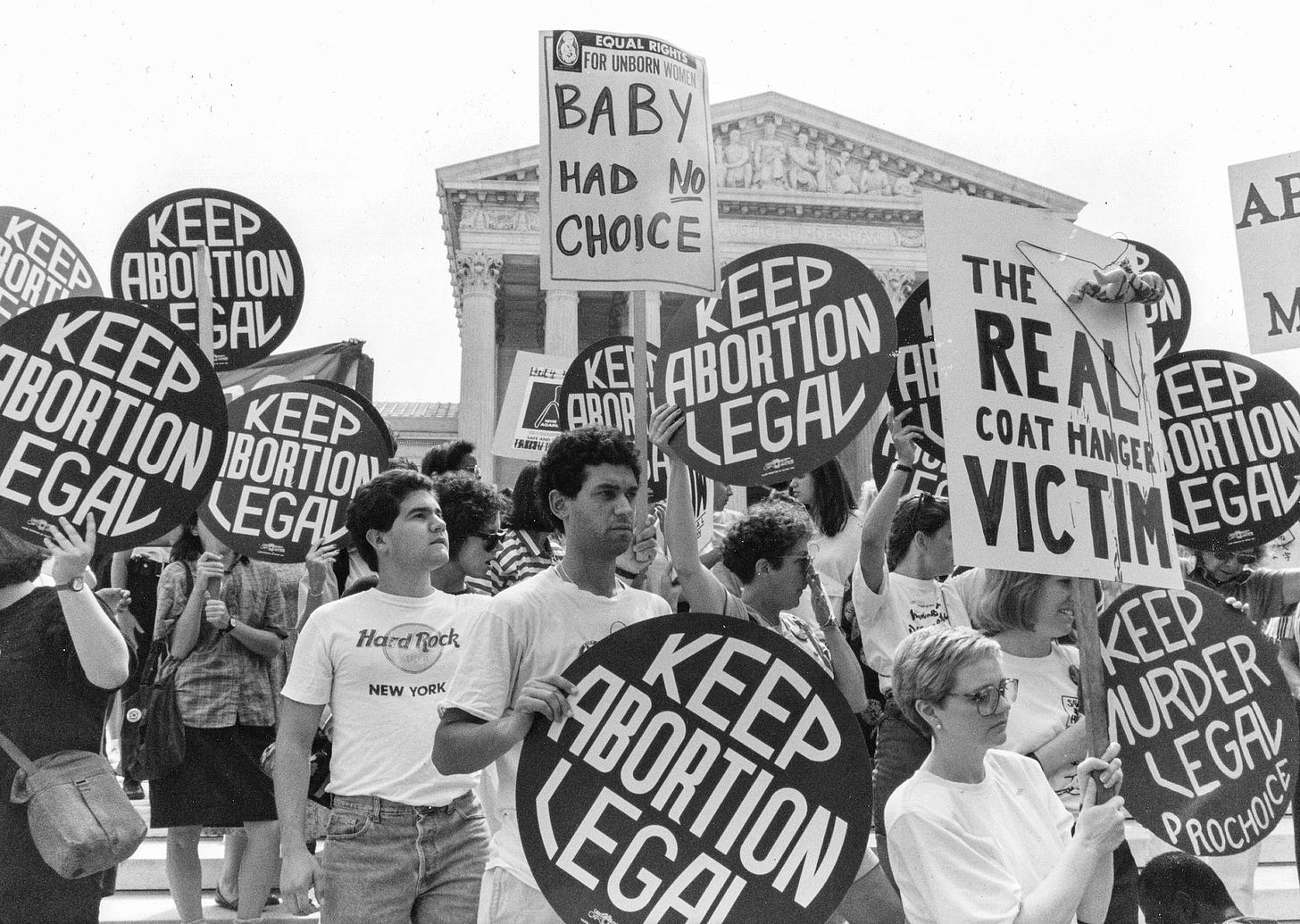 Protesters stand outside the Supreme Court holding signs that read "Keep Abortion Legal," "Baby had no cnoice" and "The real coat hanger victim"