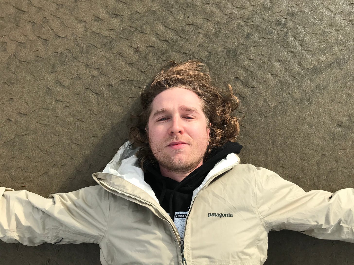 A man laying down in sand