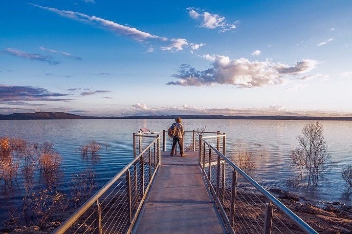 May be an image of 1 person, lake, nature and sky