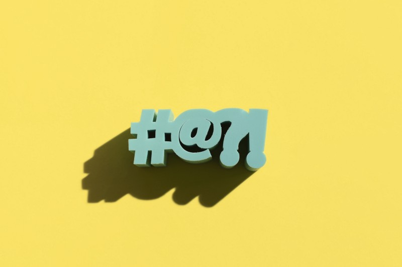 #@?! in block letters against a yellow background.