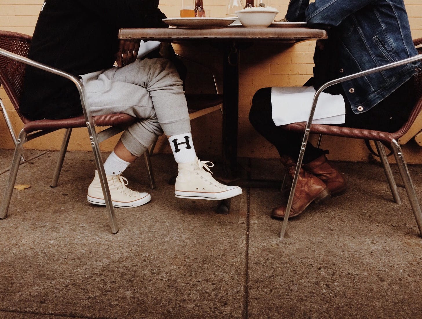 A couple sits across from one another in a cafe.