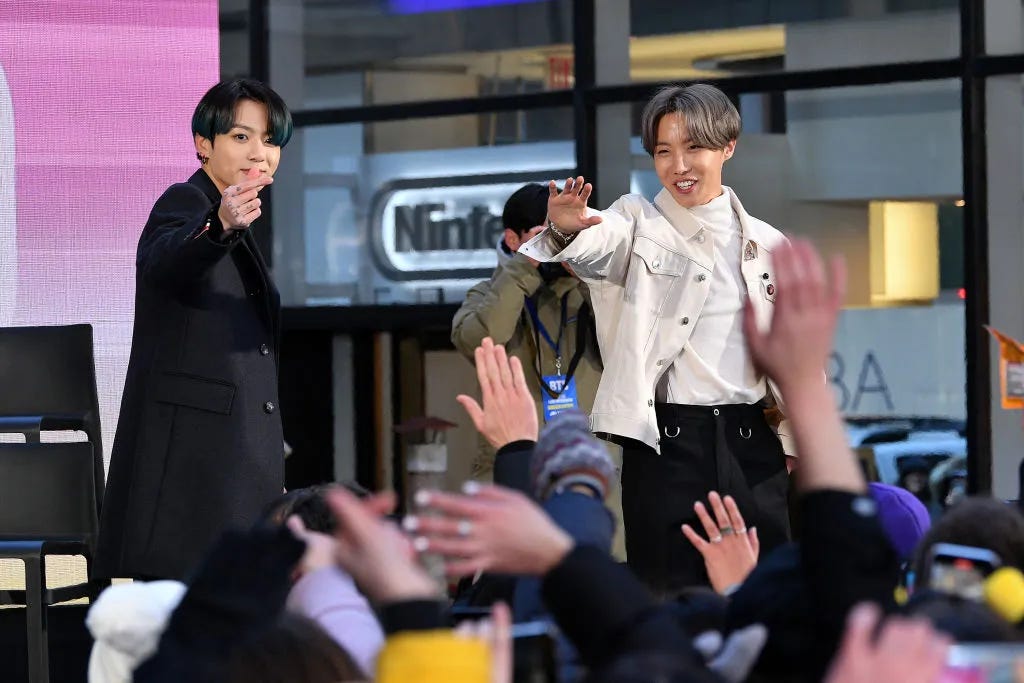 BTS' JK and J-Hope waving at fans.