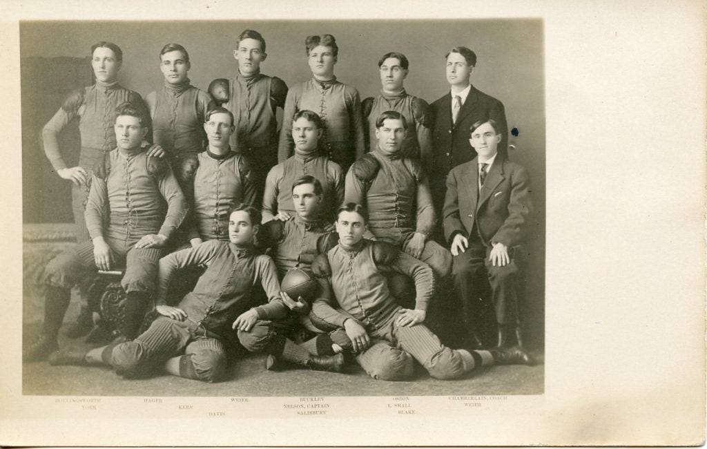 The 1908 Huron College football team poses in its vested uniforms; eight have "shoulder pads" sewn onto their jerseys.