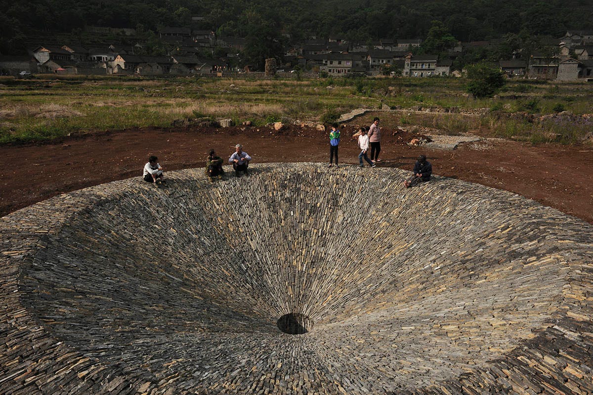 This 2,4-metre trumpet-flower-shaped sinkhole sustains rain fall cycles of  Chinese old village