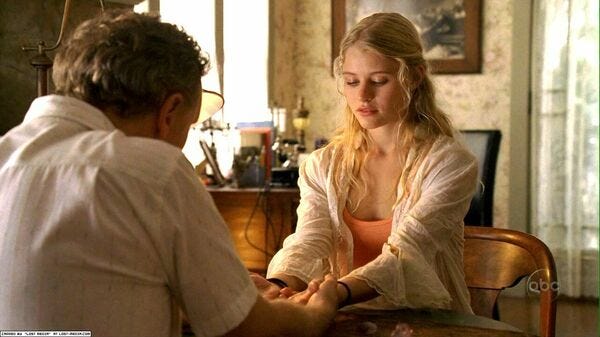 A psychic holds the hands of Claire Littleton (Emilie de Ravin) to give her a reading.