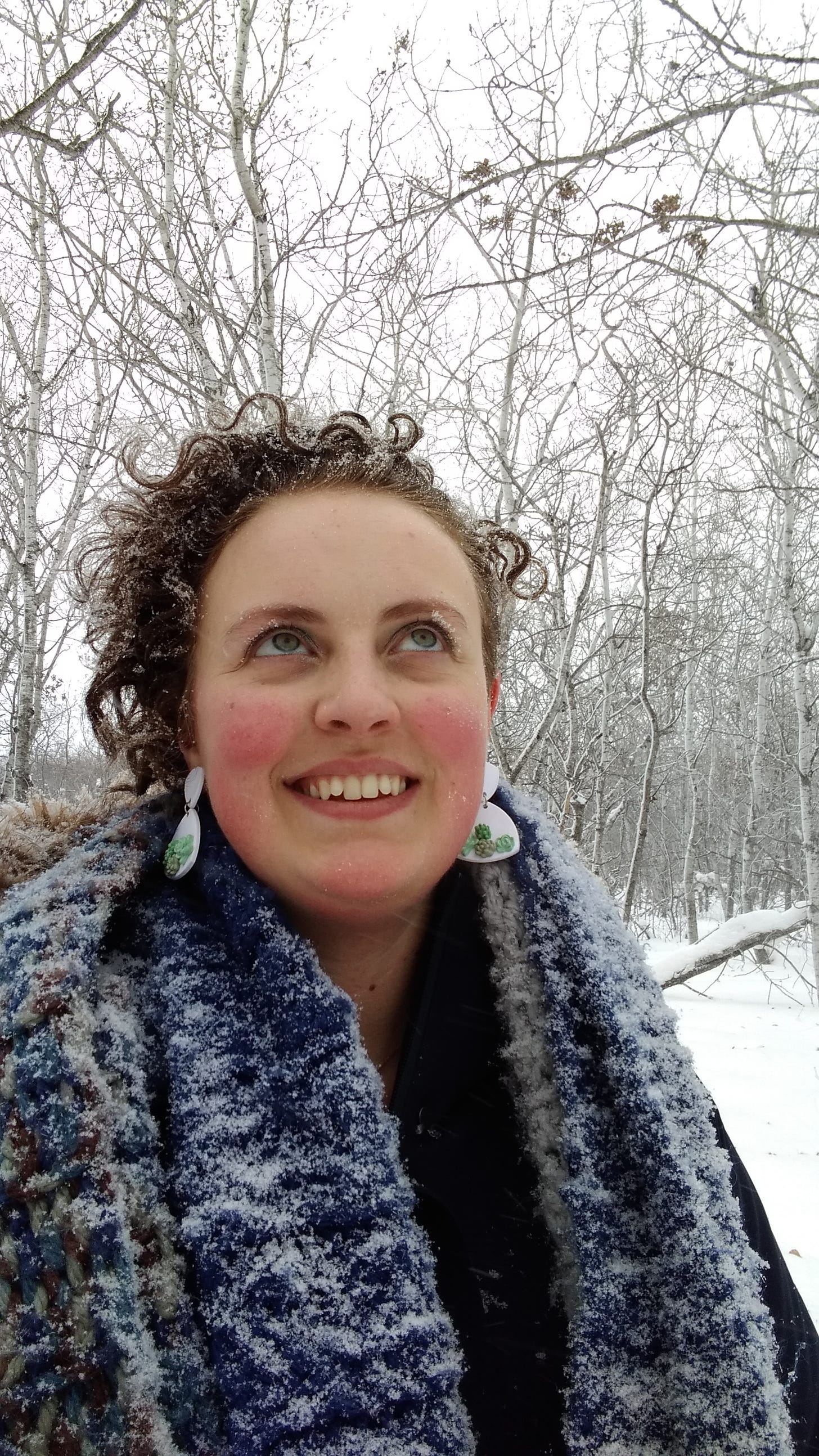 Alyssa smiling in a snowy forest