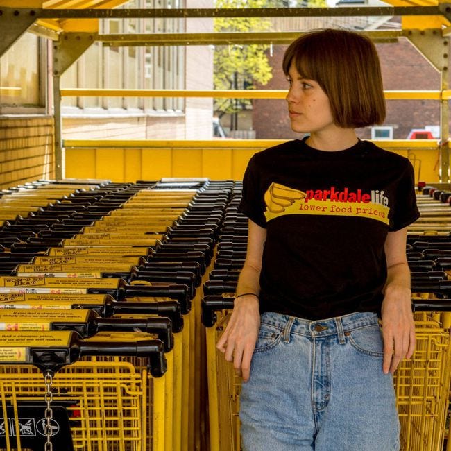 Chantelle Rose poses with grocery carts at a No Frills in the Parkdale neighbourhood of Toronto. The anonymous Instagram account Parkdale Life showed its love for Vi's No Frills, which recently reopened, by selling No-Frills-themed T-shirts with proceeds going to the Parkdale Community Food Bank.