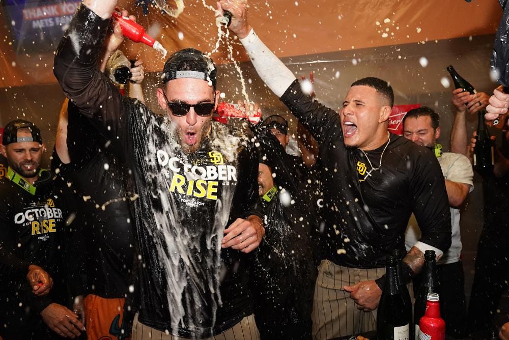 The San Diego Padres celebrate in the locker room after defeating the New York Mets in Game 3 of a National League wild-card baseball playoff series to advance to the National League Division Series against the Lost Angeles Dodgers, Sunday, Oct. 9, 2022, in New York. (AP Photo/Frank Franklin II)