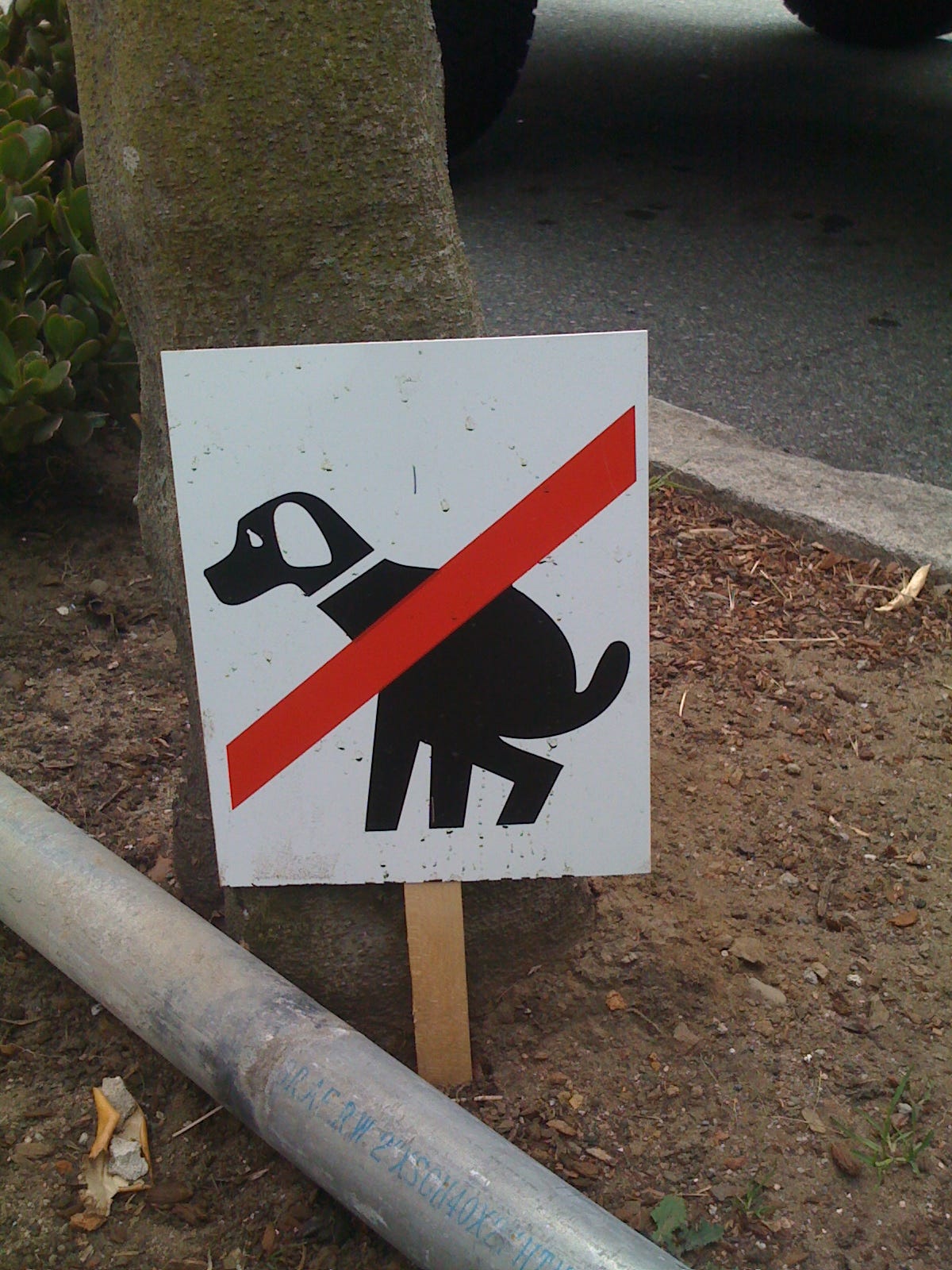 sign depicting a dog peeing with a red slash through it