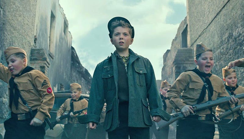 child soldiers from JoJo Rabbit charge through the streets of Berlin as the Red Army invades