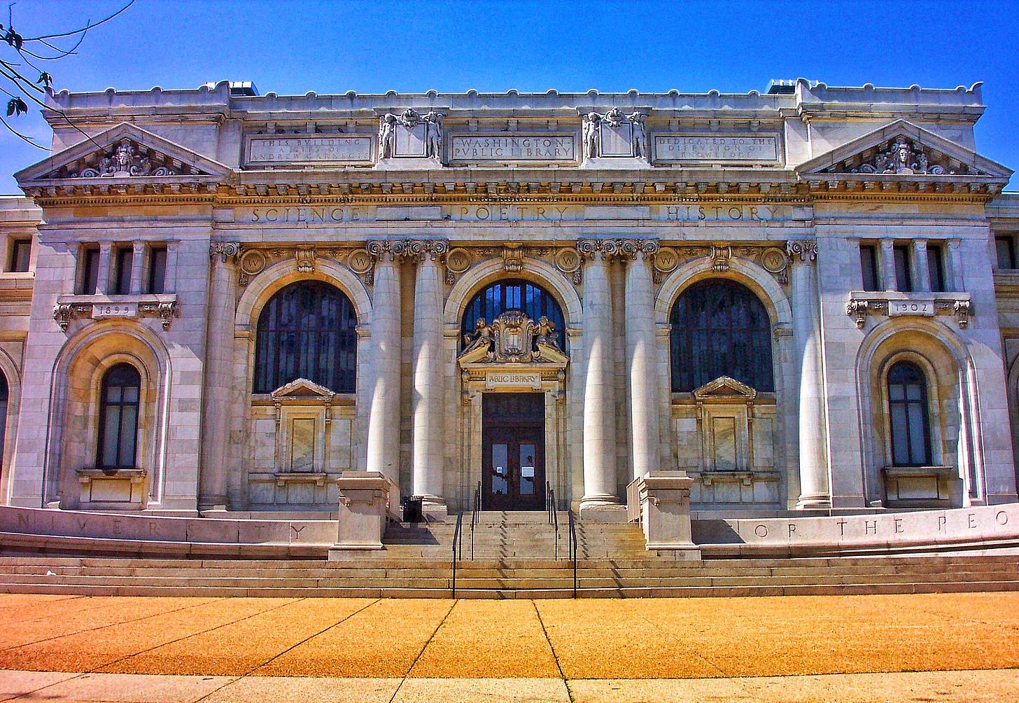 An ornate neo-classical building clad in stone. Carved into the front, it says many things, including “THIS BVILDING A GIFT OF ANDREW CARNEGIE” and “PVBLIC LIBRARY”