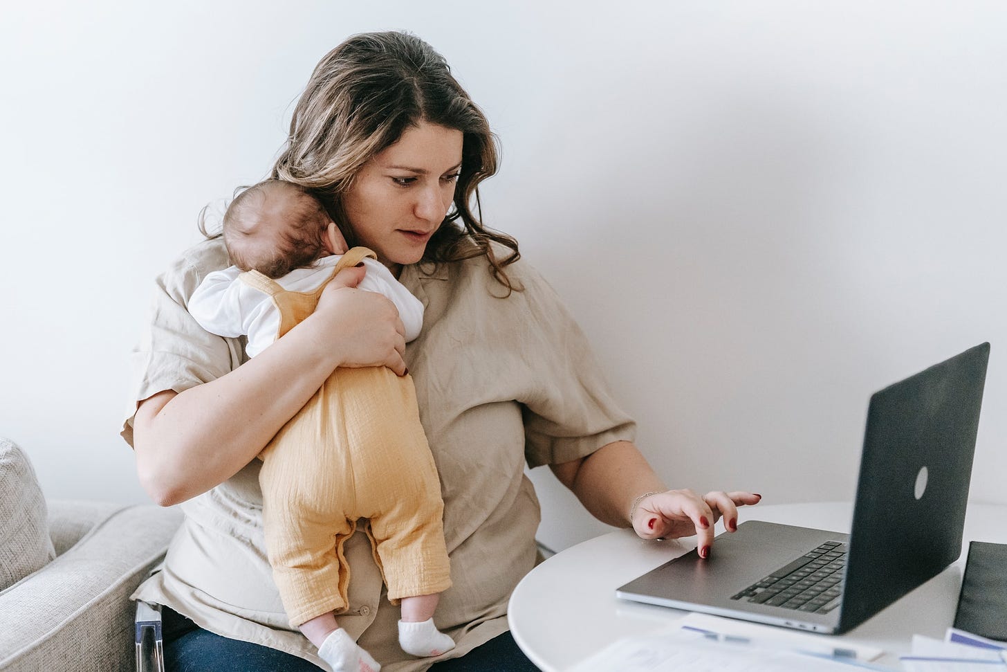 mother holding her baby while applying for unemployment insurance online