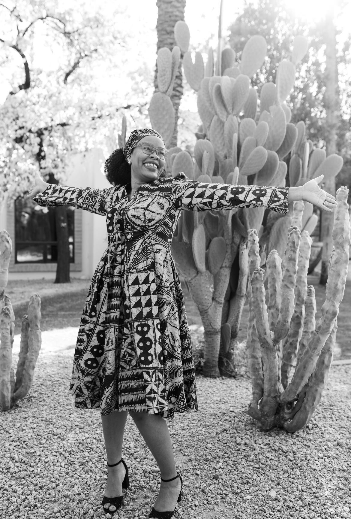 Dr. Juliet Iwelunmor- woman joyful arms out in front of cactus