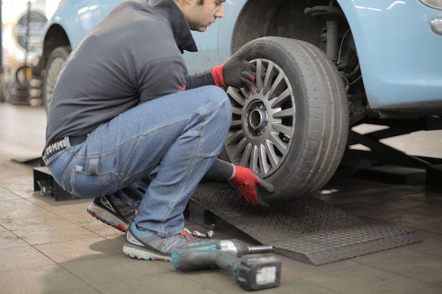 Man changing a wheel of a car