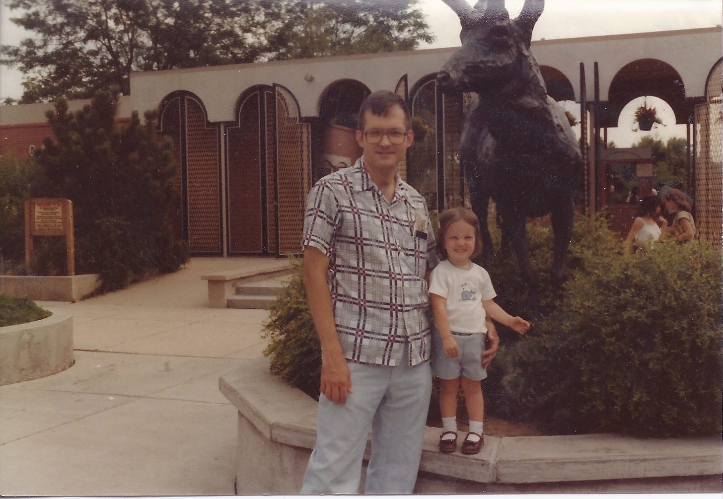 a photo of the author at age three and her father in front of the Denver Zoo