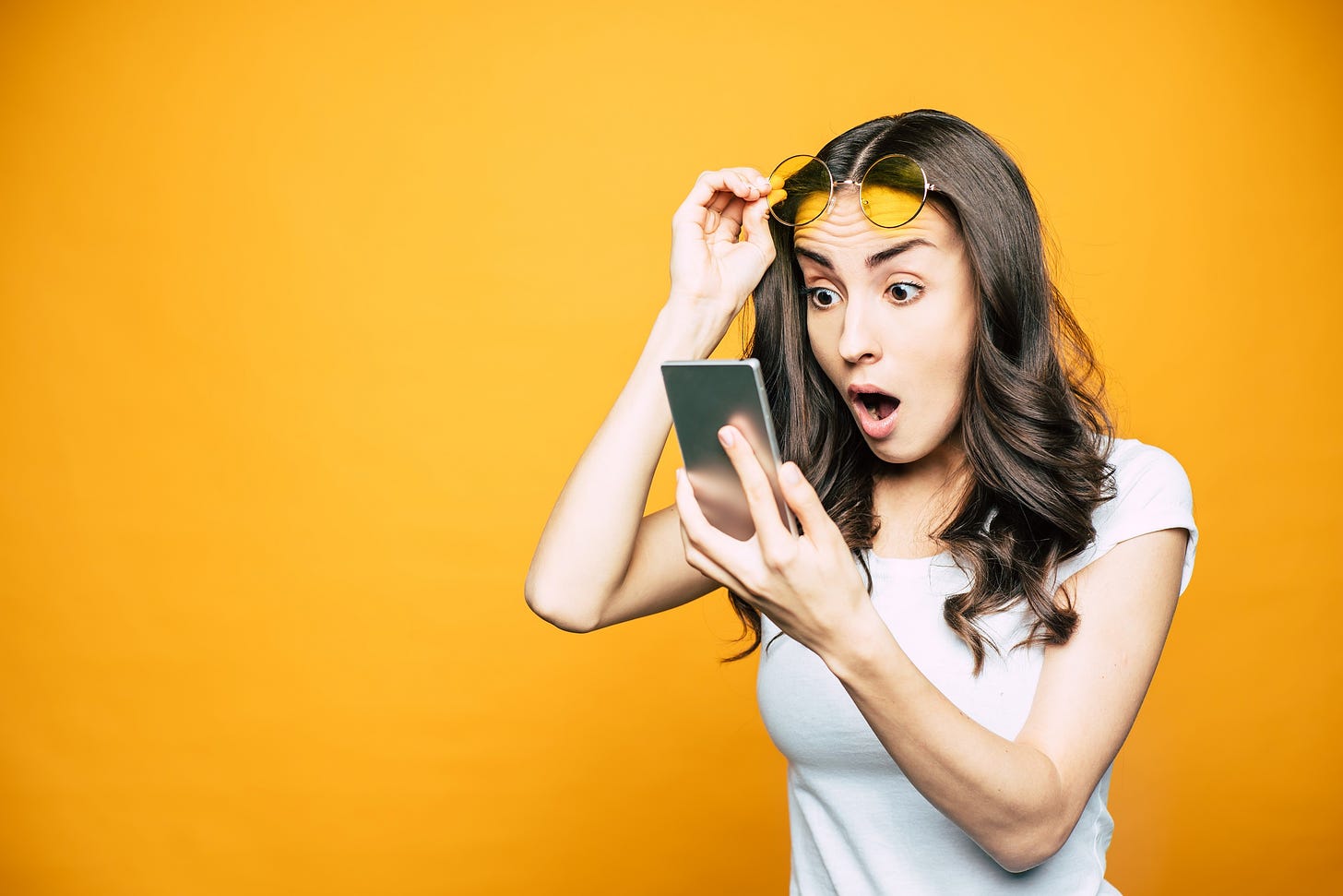 Woman with surprised expression looking at phone