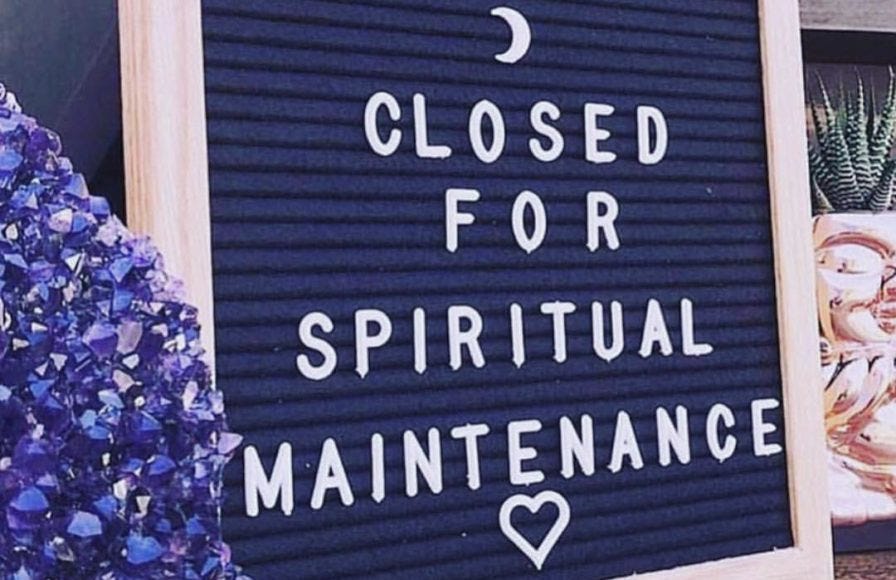 a sign that says "closed for spiritual maintenance" with a moon and heart on it. it is next to a plant and a purple crystal cluster.