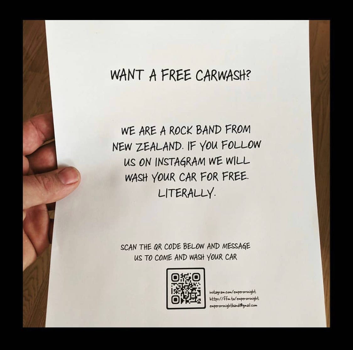 Picture of hand holding a paper flyer which reads "We are a rock band from New Zealand. If you follow us on instagram we will wash your car for free literally." At the bottom of the flyer is a QR code and links to the band's social media accounts.