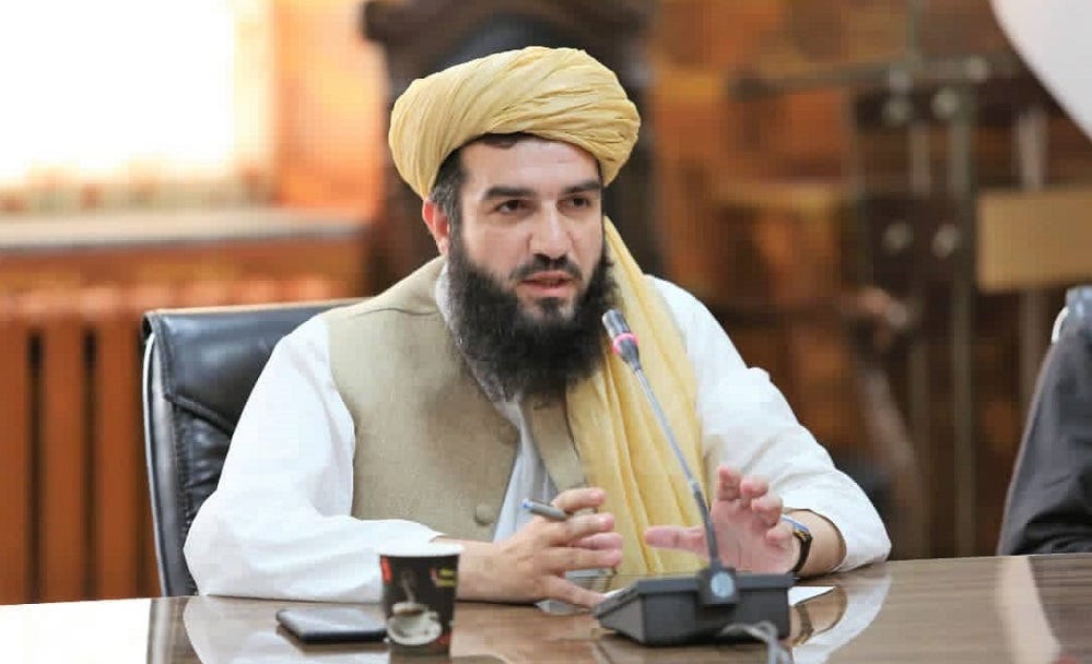 A person with a beard and a yellow headdress sitting at a table

Description automatically generated with low confidence