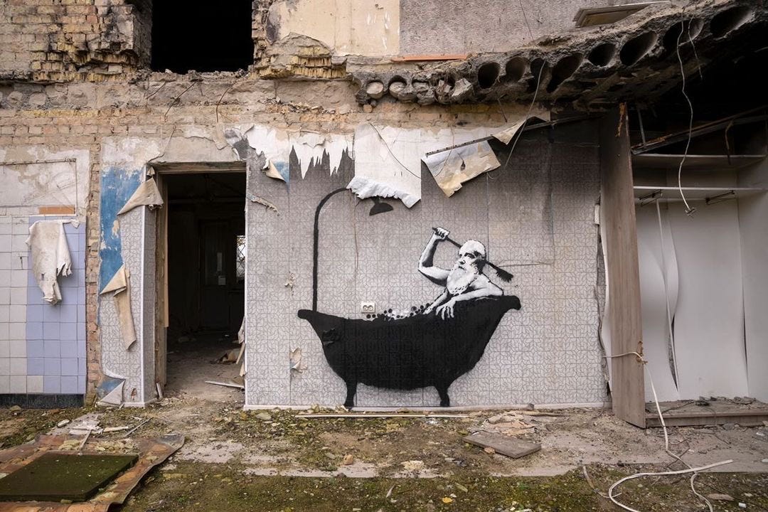 A photo of a stenciled Banksy mural on a damaged building in Ukraine