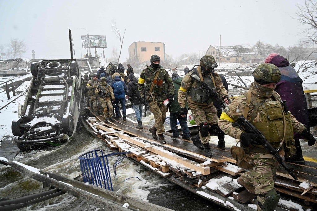 Ukrainian soldiers assist in the evacuation of civilians in Irpin.