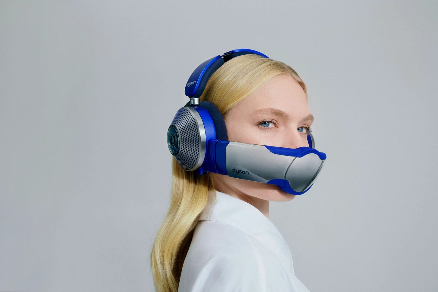 A woman looking over her shoulder. She is wearing the Dyson Zone with the air filtering visor attached, concealing her mouth.