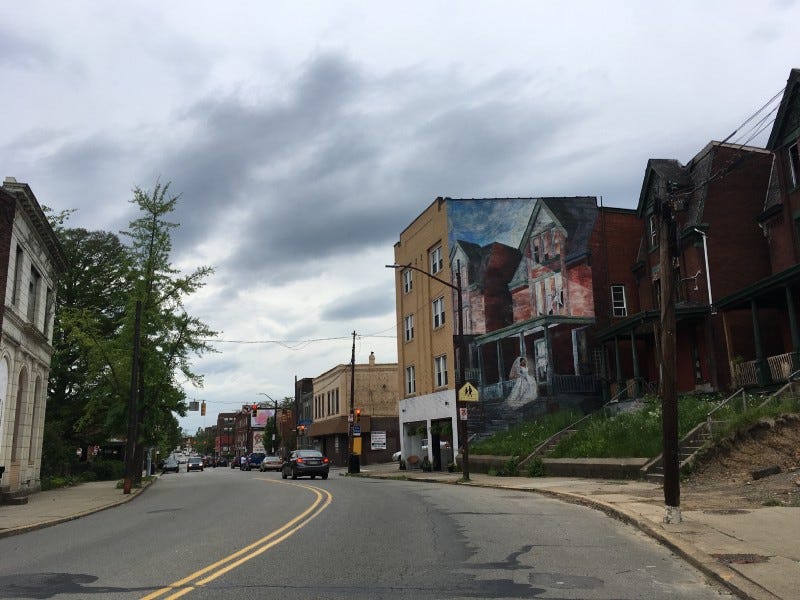 Photo of Penn Ave in Pittsburgh on an overcast day with mural of black bride in white dress on old brick building