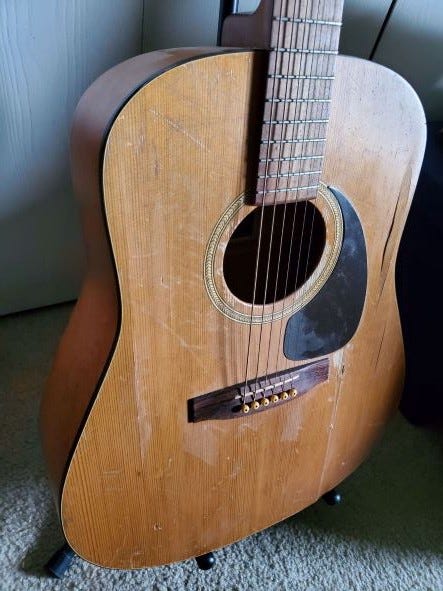 A close up photo of my busted up Seagull guitar that still plays. Photo by author.