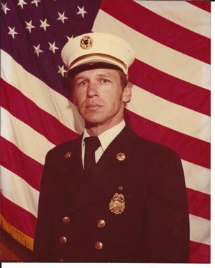 A person in uniform in front of a flag

Description automatically generated with medium confidence