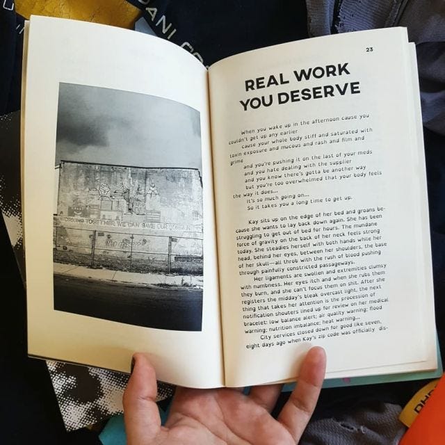 A hand holds a zine open, with a photo of a crumbling building on the left, and a story on the right