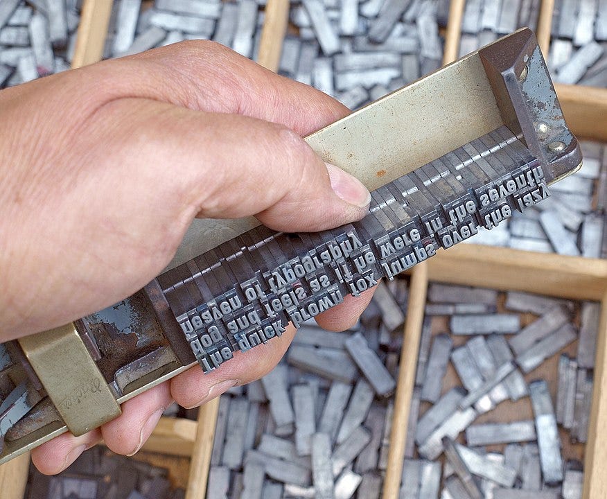 A composing stick loaded with metal movable type