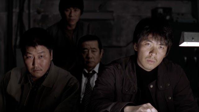 The cops of Memories of Murder staring at the camera as they interrogate their suspect