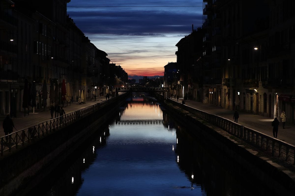 Few people walk at the Naviglio Grande canal, one of the favorite spots for night life in Milan, Italy, Tuesday, March 10, 2020