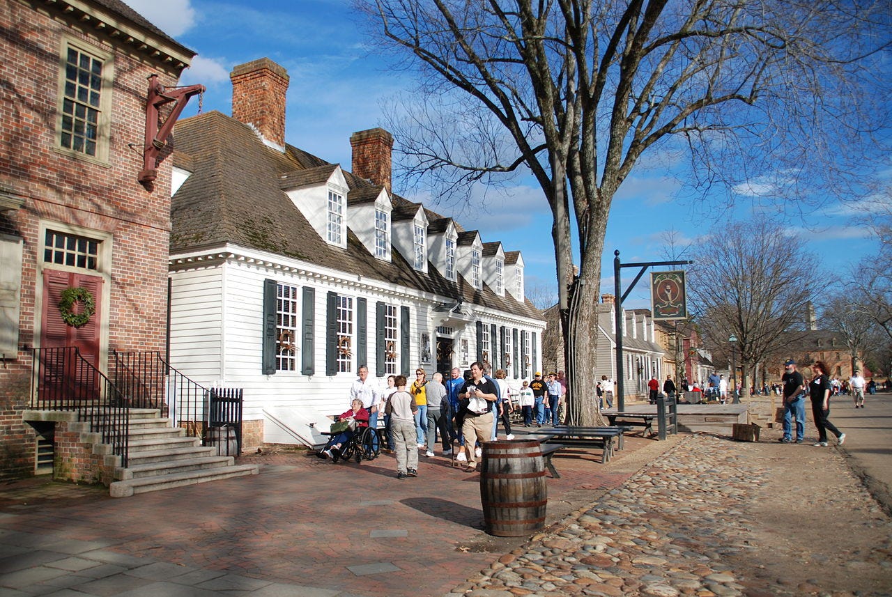Tourists walking down paved street lined with reproduced 18th century buildings