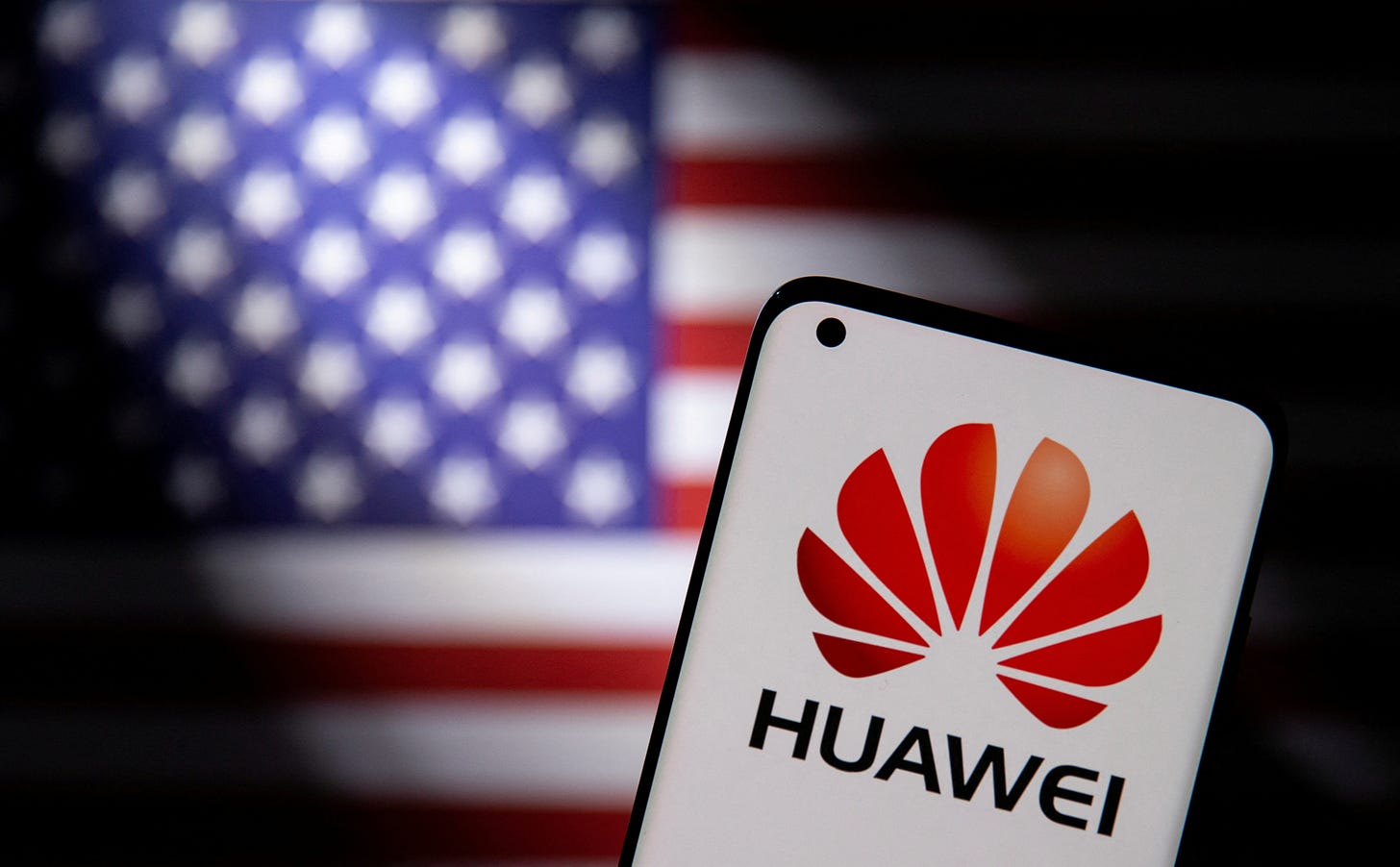 Smartphone with a Huawei logo is seen in front of U.S. flag in this illustration