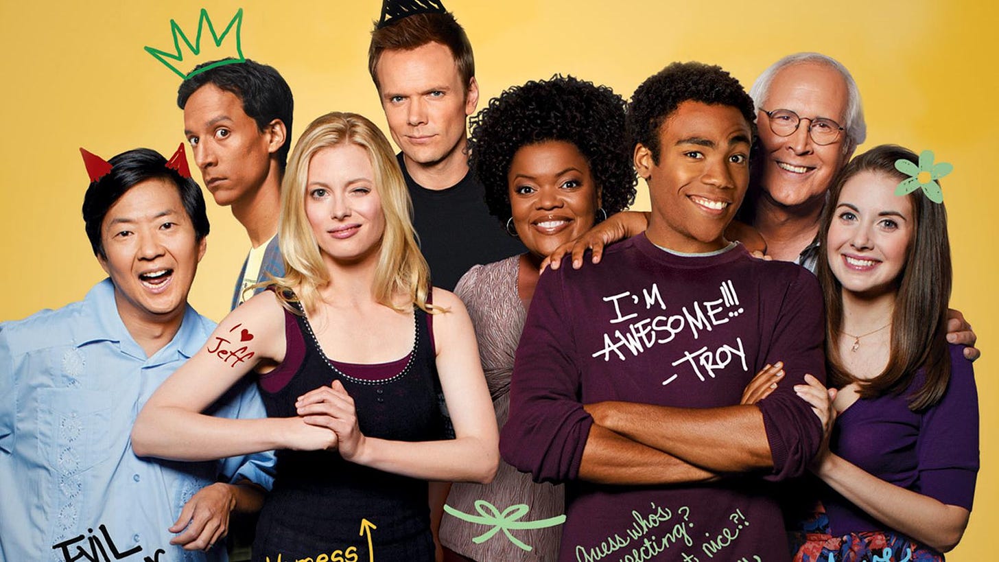 The original cast of "Community" all together and smiling at the camera.