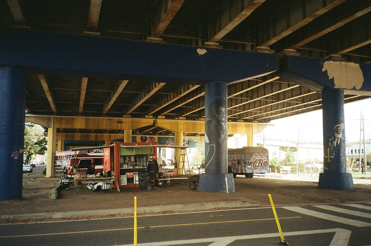 Froot Orleans, a fruit parlor, stationed between two columns of the Claiborne Expressway along the Lafitte Greenway