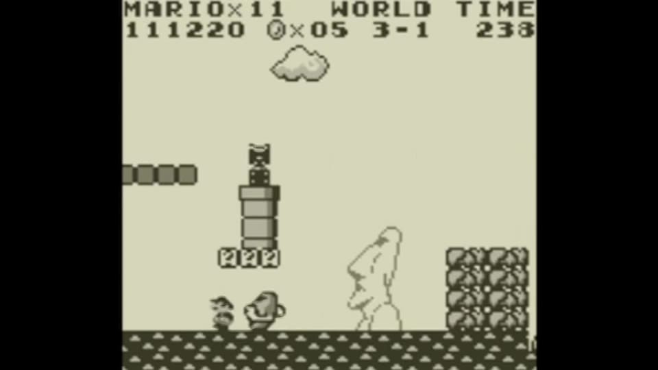 Mario running from a statue that's chasing him on the Easter Island-inspired level