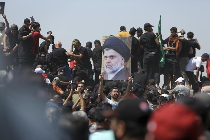 A protester holds a poster depicting Shiite cleric Muqtada al-Sadr on a bridge leading towards the Green Zone area in Baghdad, Iraq, Saturday, July 30, 2022 — days after hundreds breached Baghdad's parliament Wednesday chanting anti-Iran curses in a demonstration against a nominee for prime minister by Iran-backed parties.(AP Photo/Anmar Khalil)