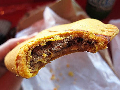 a Jamaican meat patty with a bite taken out