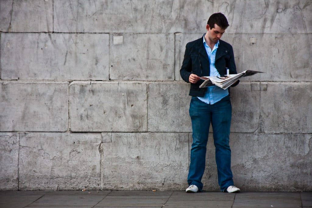 "Reading A Newspaper By A Wall" by garryknight is licensed under CC BY 2.0