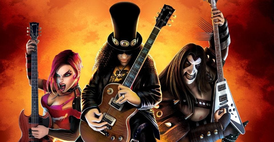 Three animated characters from the Guitar Hero franchise. In the centre is a guitarist who resembles Slash from the band Guns and Roses, he wears a top hat and has long frizzy hair. The guitarist on the left is a woman with pink hair and a wild expression on her face. On the right is a guitarist with long hair and white and black face paint, resembling the band KISS.