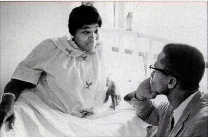 This image shows Betty Shabazz talking with her husband, Malcolm X. Betty reclines on a bed or sofa while Malcolm gazes up at her, listening intently as she talks to him. This image shows Betty Shabazz talking with her husband, Malcolm X. Betty reclines on a bed or sofa while Malcolm gazes up at her, listening intently as she talks to him.